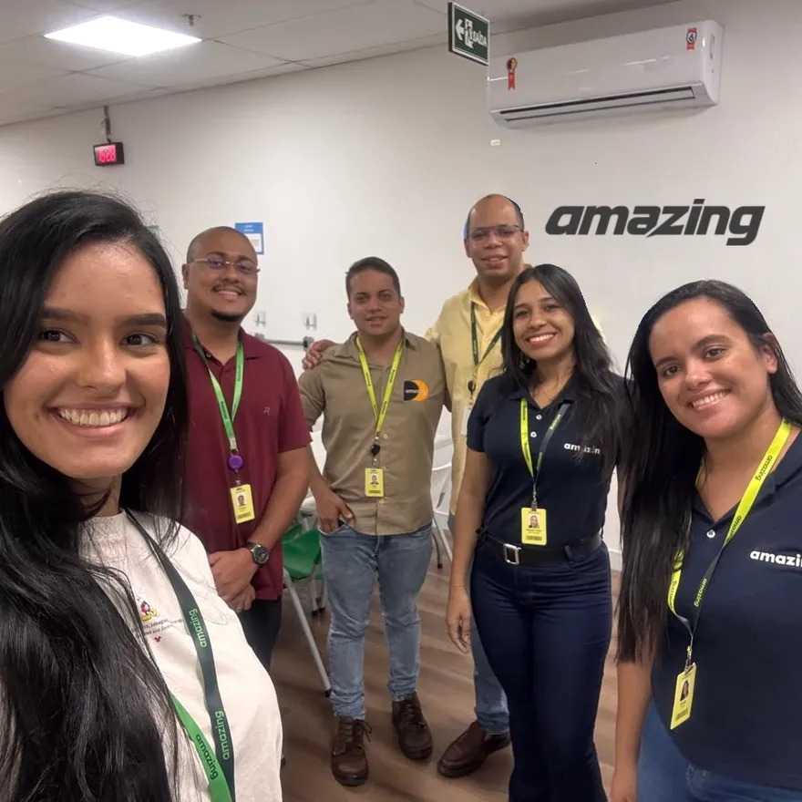 Equipe de suporte da Amazing reunida na sala da operação, com crachás da empresa
